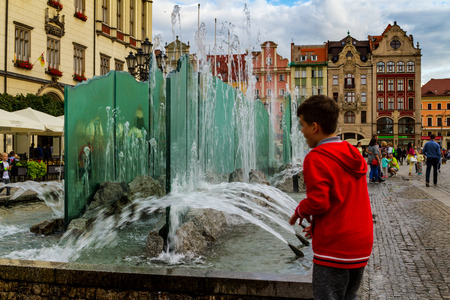 Wroclaw, Silesia, Poland - July 25, 2017: Tourists view a modern fountain and historic buildings on the market square.のeditorial素材