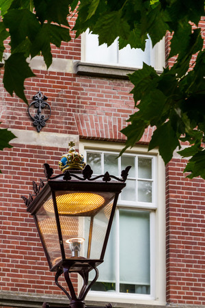 AMSTERDAM, NETHERLANDS - JULY 27, 2017: A street lamp with a crown on the background of a house window on one of the central streets.のeditorial素材