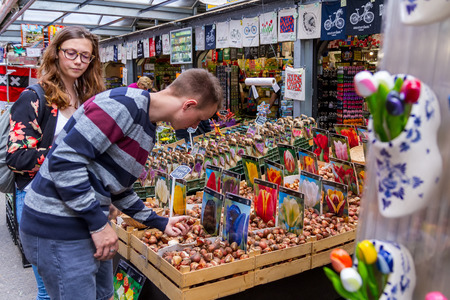 AMSTERDAM, NETHERLANDS - 27 JULY 2017:Tourists buy tubers of tulips in the souvenir market in the historic center of Amsterdam.のeditorial素材