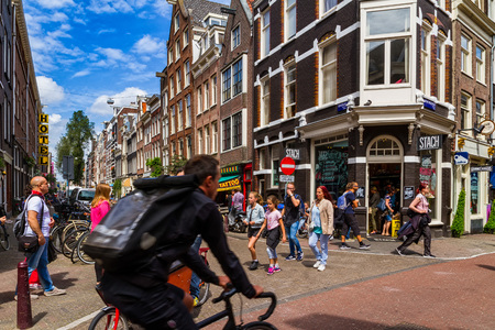AMSTERDAM, NETHERLANDS - 27 JULY 2017: Tourists view historic houses at one of the crossroads in the center of Amsterdam.のeditorial素材