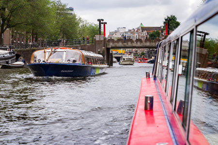 AMSTERDAM, NETHERLANDS - 27 JULY 2017: Excursion boat floating one away from the central channel in Amsterdam.のeditorial素材