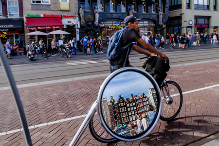 AMSTERDAM, NETHERLANDS - 27 JULY 2017: Reflection of historic houses in the mirror of a scooter parked in the center of Amsterdam.のeditorial素材