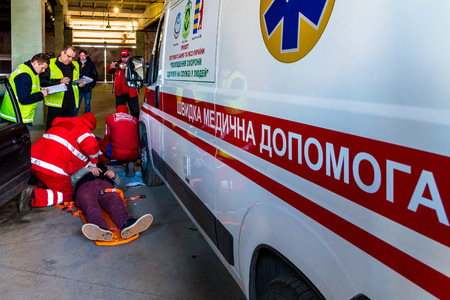 Uzhgorod, Ukraine - November 16, 2017: The emergency medical teams assisting conditional victim during the competition.のeditorial素材