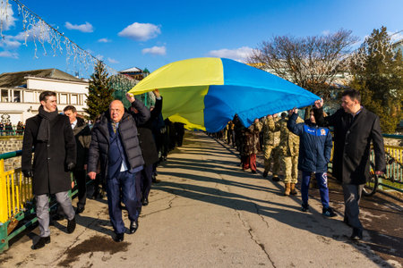 Uzhgorod, Ukraine - January 22, 2018: People carry a 100-meter Ukrainian flag across the bridge...