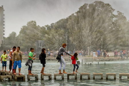 Debrecen, Hungary - August 20, 2017: Tourists walk through the fountain under the spray of water in the park after the 48th Flower Carnival in Debrecen, Hungary.のeditorial素材
