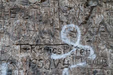 Inscription in Cyrillic and Latin on a concrete wall among the ruins of Nevitsky Castle, Ukraine.の写真素材