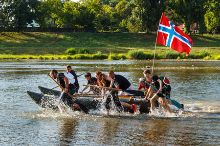 Uzhgorod, Ukraine - July 29, 2018: Group of young people push the boat under the Norwegian flag during rafting on the river Uzh.のeditorial素材