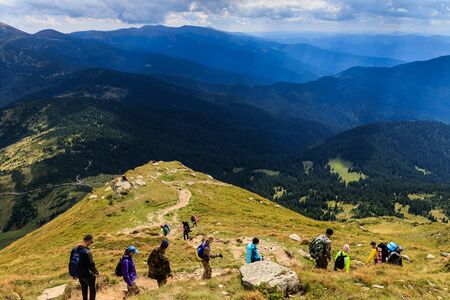 Tourists go down the path from the top of Mount Petros in the Ukrainian Carpathians. Near the village of Lazeshchyna, Ukraine - September 7, 2019.のeditorial素材