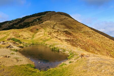 Small lake at the top of Strymba mountain on a beautiful autumn day near the village of Kolochava, Ukraine.の写真素材