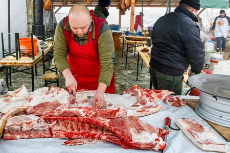 Hecha, western Ukraine - January 25, 2020: A butcher cuts pork during the traditional winter festival of butchers in the village of Hecha in western Ukraine.のeditorial素材