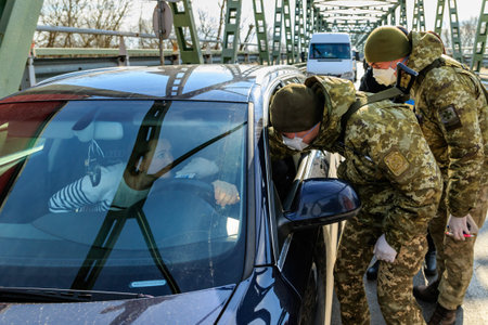 Chop, Ukraine - February 25, 2020: Border guards conduct temperature control of citizens crossing...