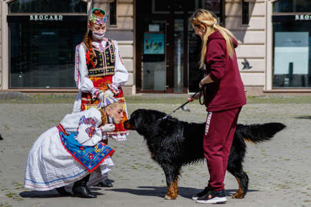 Uzhgorod, Ukraine - May 21, 2020. A girl in a Ukrainian national costume kisses a dog during an art mob on the occasion of Embroidered Shirt Day.のeditorial素材