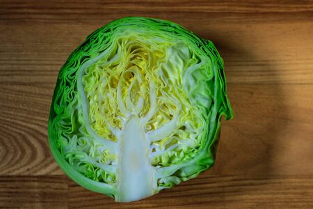 Half fresh young cabbage on a wooden board in natural light.の写真素材