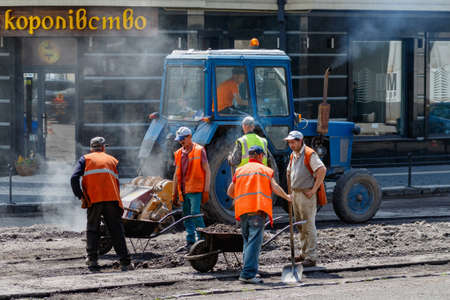 Uzhgorod, western Ukraine - June 11, 2020: Employees of municipal services, repair pavement in the city center during the quarantine due to coronavirus.のeditorial素材