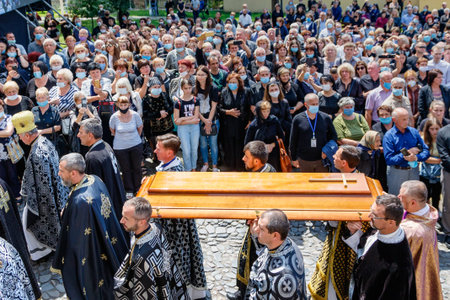 Uzhgorod, Ukraine - July 20, 2020: Priests carry the lid of the coffin during the farewell ceremony...
