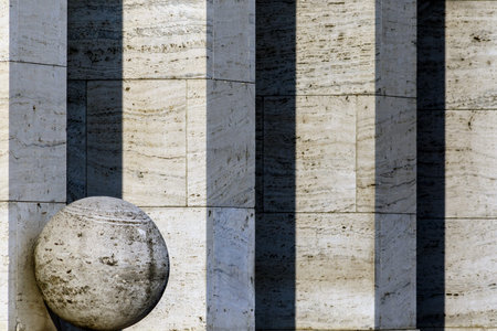 Stone ball in front of a row of columns. Architectural background.