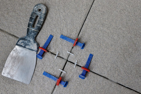 Tile leveling system with plastic wedges. Installation of floor tiles. Ceramic tiles and tools.