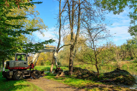 Beregovo, Ukraine - October 20, 2020: Excavator clean the riverbed from silt and debris after the autumn floods.のeditorial素材