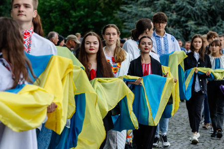 Uzhgorod, Ukraine - August 24, 2021: Young people hold a 100-meter flag during a solemn procession...
