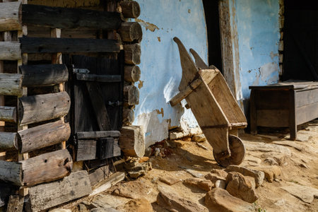 Wooden wheelbarrow near the blue wall of the old barn in one of the villages in western Ukraine.の写真素材