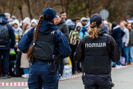 Uzhgorod, Ukraine - February 26, 2022: Ukrainian policewomen work with refugees leaving the country through the Ukrainian-Slovak border.のeditorial素材