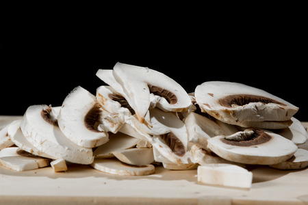 Fresh whole white button mushrooms, or agaricus, in a bowl on a rustic woodenの写真素材