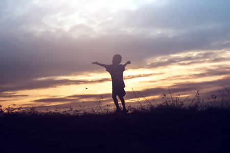 Silhouette of kid and the beautiful sky in the evening