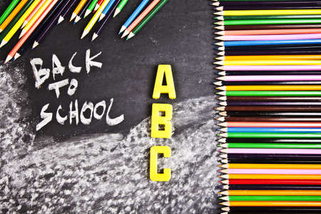 Chalk, colour wooden pencils and letters on blackboard の写真素材