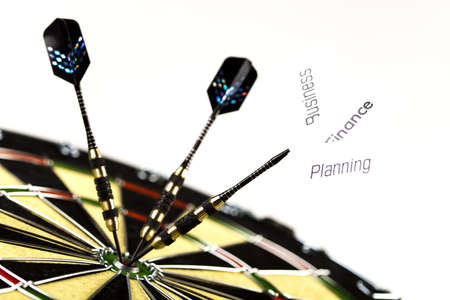Dartboard with three darts in a bulls eyeの写真素材