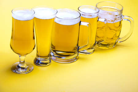 Beer glass with yellow background の写真素材