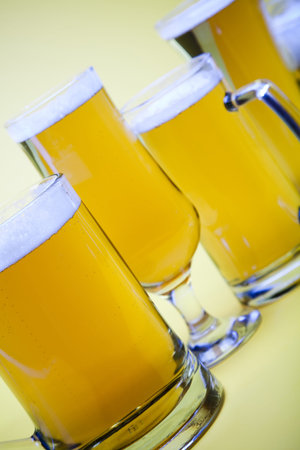 Beer glass with yellow background の写真素材