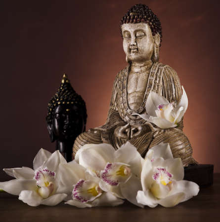 Buddha statue with orchid flowerの写真素材