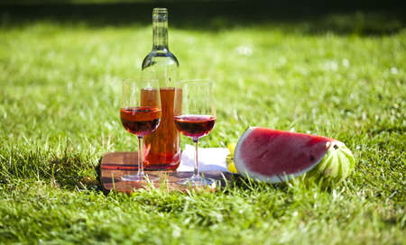 Wine and picnic basket on the grass の写真素材
