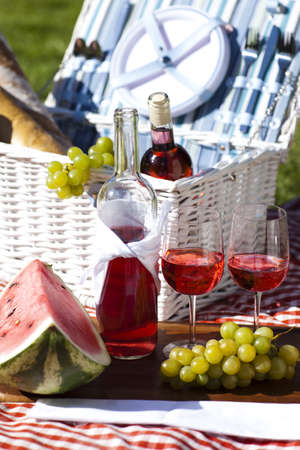 Wine and picnic basket on the grass の写真素材