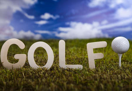 Golf ball on green grass over a blue sky の写真素材