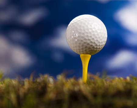 Golf ball on green grass over a blue sky の写真素材