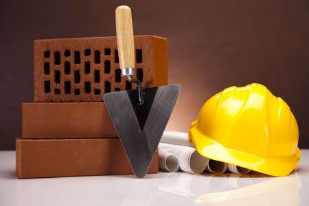 Hard hat with bricks and trowelの写真素材