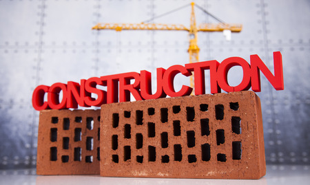 Building under construction with crane, on blueprintsの写真素材