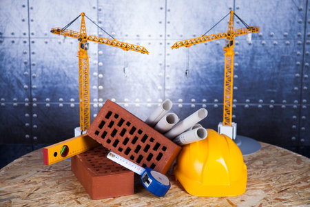 Building under construction with crane, on blueprints