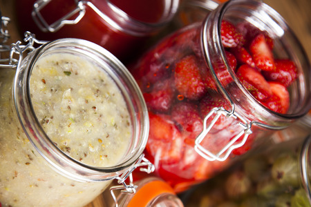 Berries jam in glass jar and wood backgroundの写真素材