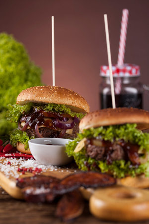 Close-up of home made burgers, wooden desk backgroundの写真素材