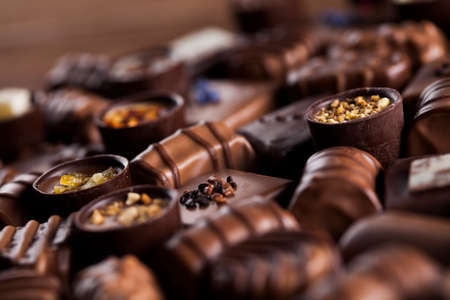Chocolate bars and pralines on wooden backgroundの写真素材