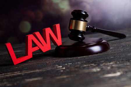 Law theme, mallet of the judge, justice scale, wooden desk backgroundの写真素材