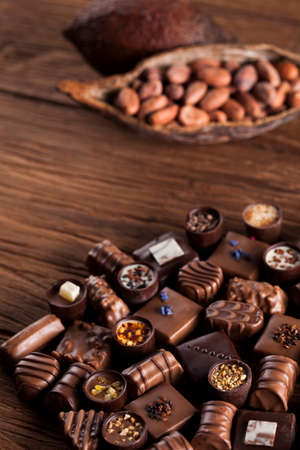 Chocolate bars and pralines on wooden backgroundの写真素材
