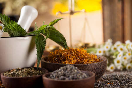 Herbs medicine,Natural remedy and mortar on vintage wooden desk backgroundの写真素材