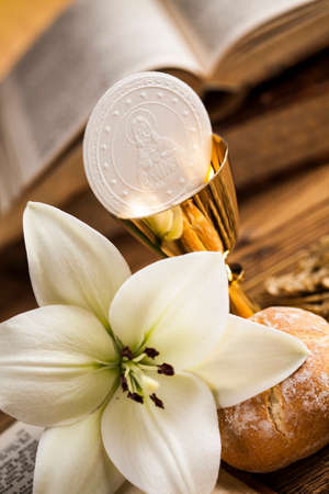 Holy communion a golden chalice with grapes and bread wafersの写真素材
