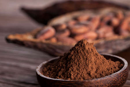 Cocoa beans in the dry cocoa pod fruit on wooden backgroundの写真素材