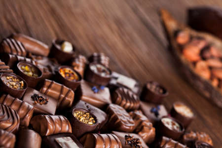 Chocolate bars and pralines on wooden backgroundの写真素材