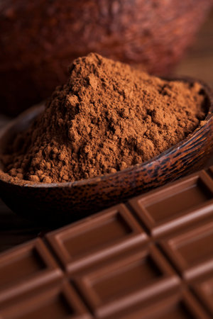 Chocolate bar, candy sweet, cacao beans and powder on wooden background