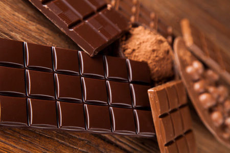 Aromatic cocoa and chocolate on wooden background